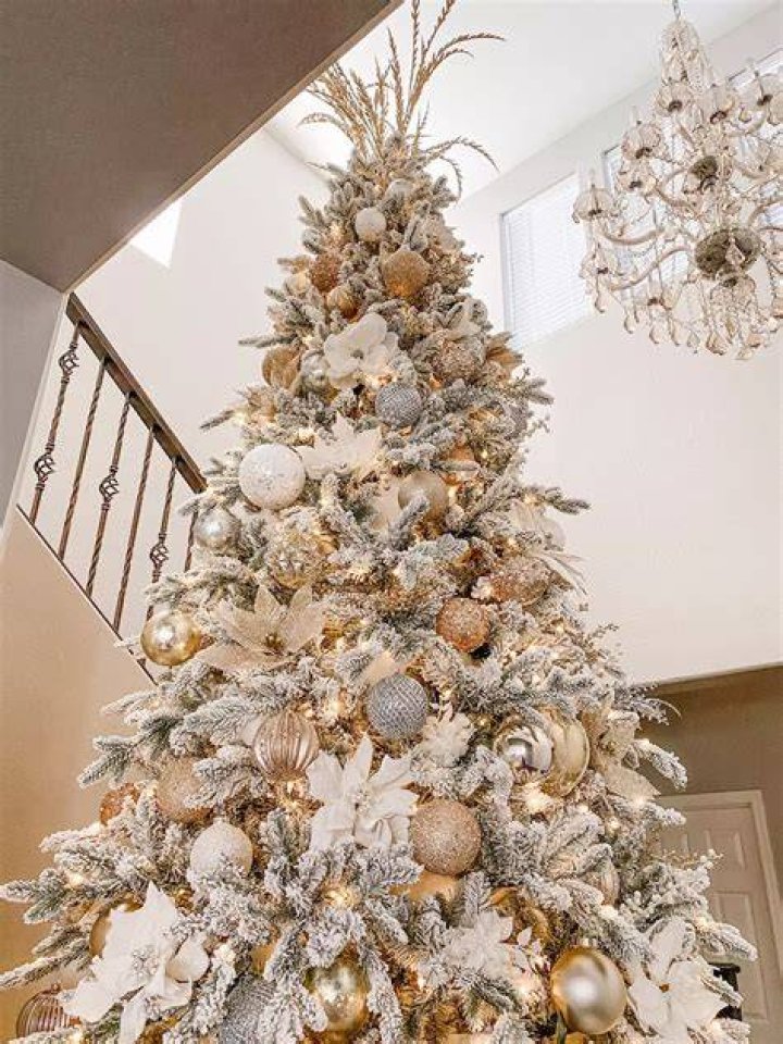 a white and gold christmas tree made out of wine bottles