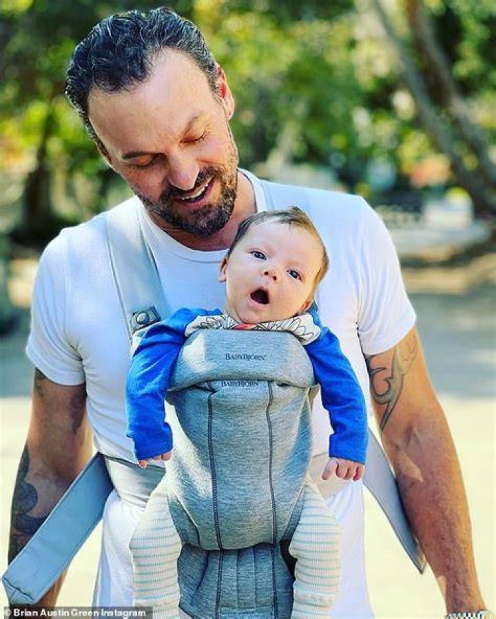 Brian Austin Green cradles his and girlfriend Sharna Burgess' newborn
