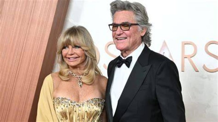Goldie Hawn lovingly holds longterm beau Kurt Russell by the arm