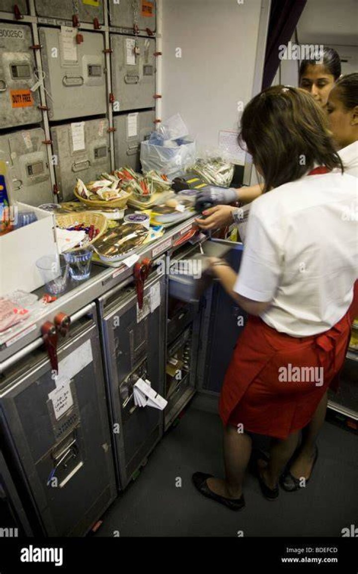 Members of cabin crew prepare to serve meals in the galley of a Virgin