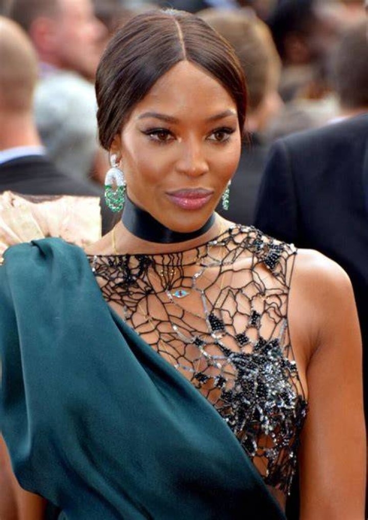Naomi Campbell in a black dress and sandals at a party for