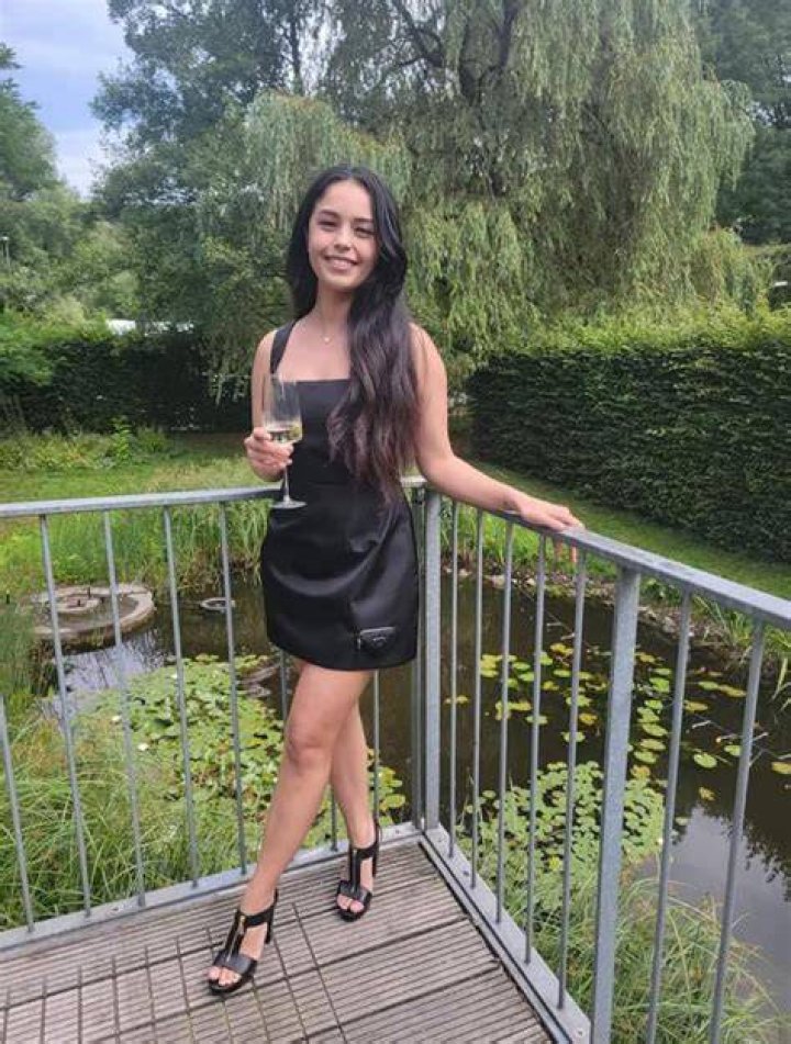 Rae posing in a garden in California
